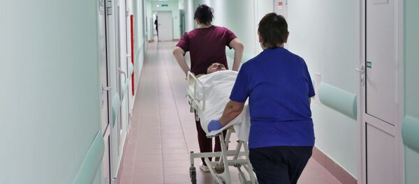 Медсестры везут каталку с больным по коридору в больнице, архивное фото - Sputnik Беларусь
