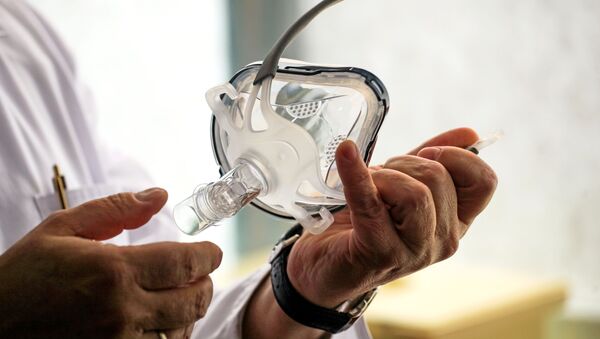 Лекар трымае ў руках маску для штучнай вентыляцыі лёгкіх, архіўны фотаздымак - Sputnik Беларусь