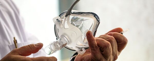 Врач держит в руках маску для искусственной вентиляции легких, архивное фото  - Sputnik Беларусь