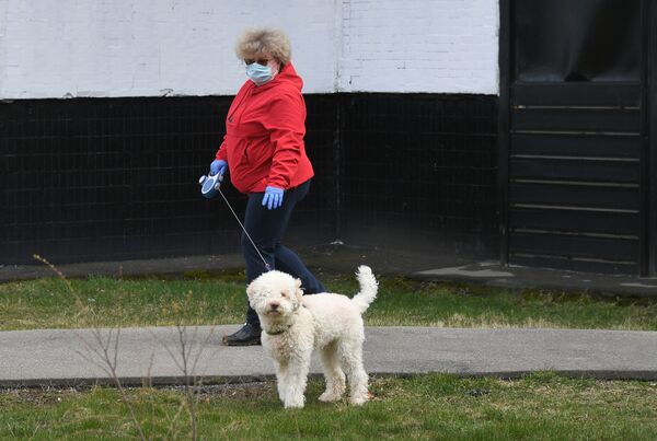 Женщина гуляет с собакой возле своего дома в Москве - Sputnik Беларусь