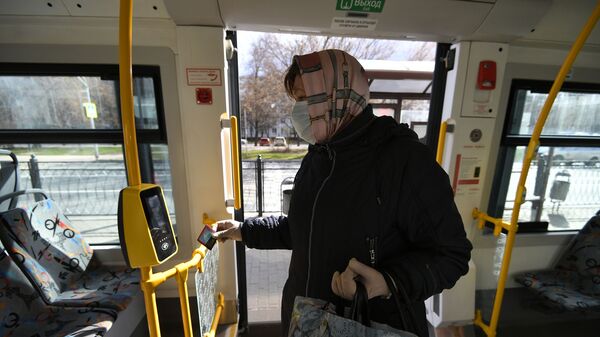 Женщина в защитной маске в салоне городского автобуса - Sputnik Беларусь