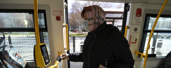 Женщина в защитной маске в салоне городского автобуса - Sputnik Беларусь