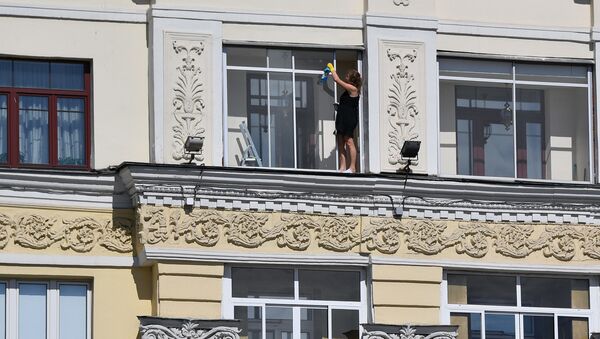 Женщина моет окно в квартире на проспекте Независимости в Минске - Sputnik Беларусь