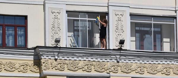 Женщина моет окно в квартире на проспекте Независимости в Минске - Sputnik Беларусь