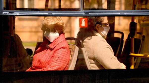 Женщины в защитных масках едут в общественном транспорте - Sputnik Беларусь
