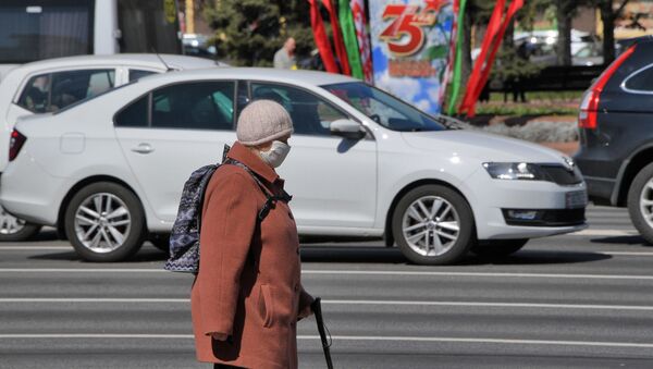 Женщина в защитной маске идет по проспекту Независимости в Минске - Sputnik Беларусь
