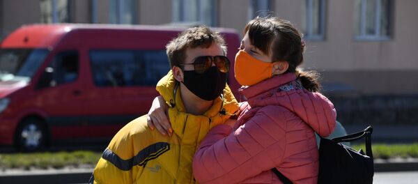 Парень и девушка в защитных масках ждут автобус на остановке Парень и девушка в защитных масках ждут автобус на остановке - Sputnik Беларусь