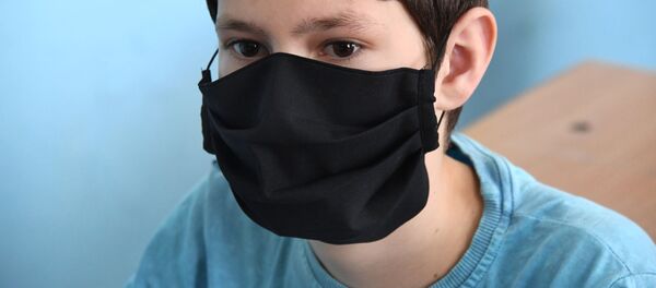 Школьник в защитной маске, архивное фото - Sputnik Беларусь