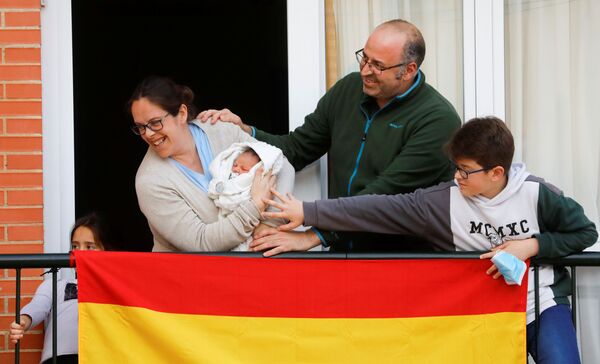 Семья из Ронды показывает соседям своего новорожденного ребенка в период пандемии коронавируса в Испании - Sputnik Беларусь