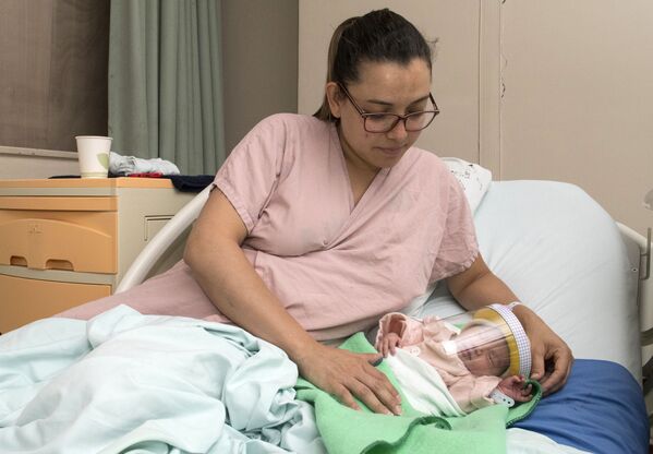 Женщина с новорожденным ребенком в защитной маске в отделении неонатологии мексиканской больницы в Сан-Хосе, Коста-Рика - Sputnik Беларусь