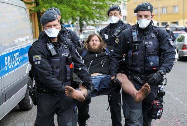 Полицейские в защитных масках задерживают человека во время демонстрации против карантина в Берлине, Германия - Sputnik Беларусь