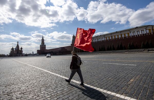 Сторонник Коммунистической партии России несет флаг СССР по Красной площади в Москве 1 мая 2020 года - Sputnik Беларусь