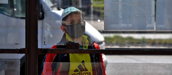 Мальчик в защитной маске на остановке транспорта в Минске - Sputnik Беларусь