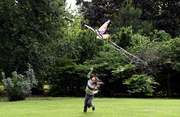 Девочка во время игры с воздушным змеем в Милане после этапного завершения карантина в Италии - Sputnik Беларусь