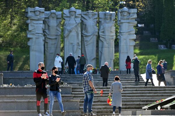 В Литве, несмотря на карантин, жители столицы отправились к мемориалам павших советских воинов, чтобы возложить цветы в честь их подвига  - Sputnik Беларусь