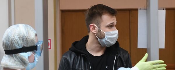 Мужчына пасля вымярэння тэмпературы пры ўваходзе ў лячэбную ўстанову Мужчына пасля вымярэння тэмпературы пры ўваходзе ў лячэбную ўстанову - Sputnik Беларусь