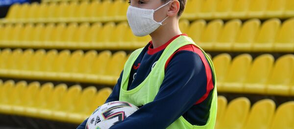 Мальчик, подающий мячи, в защитной маске - Sputnik Беларусь