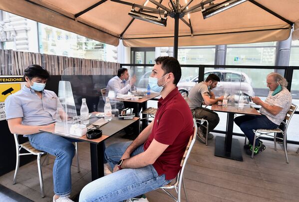 Люди в защитных масках сидят на террасе ресторана в Милане, Италия - Sputnik Беларусь