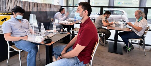 Люди в защитных масках сидят на террасе ресторана в Милане, Италия - Sputnik Беларусь