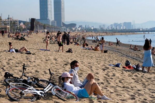 Люди в масках наслаждается солнечной погодой на пляже в Барселоне, Испания - Sputnik Беларусь