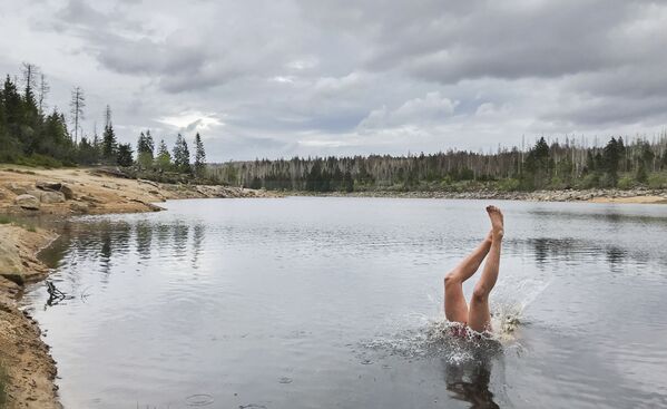 Мужчина прыгает в водохранилище Одертайх в Национальном парке Гарц недалеко от Одербрюка - Sputnik Беларусь
