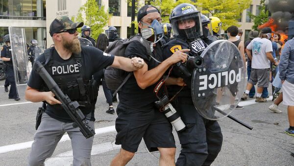 Полицейский толкает фотографа во время протестов в США  - Sputnik Беларусь
