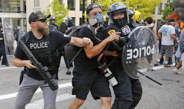 Полицейский толкает фотографа во время протестов в США  - Sputnik Беларусь