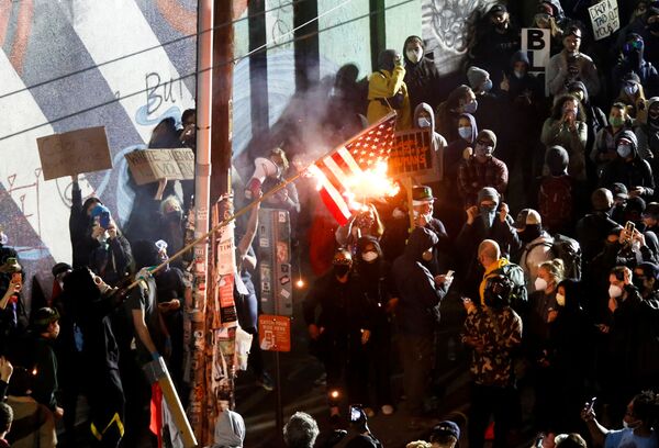 Пратэстоўцы спальваюць амерыканскі сцяг падчас акцыі пратэсту супраць расавай няроўнасці ў Сіэтле - Sputnik Беларусь
