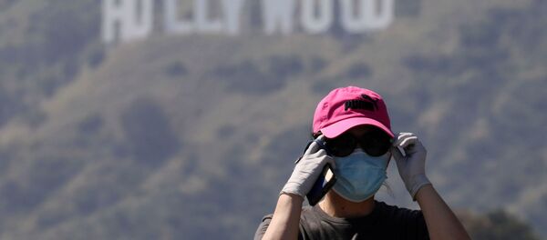 Человек в маске не фоне надписи Hollywood  - Sputnik Беларусь