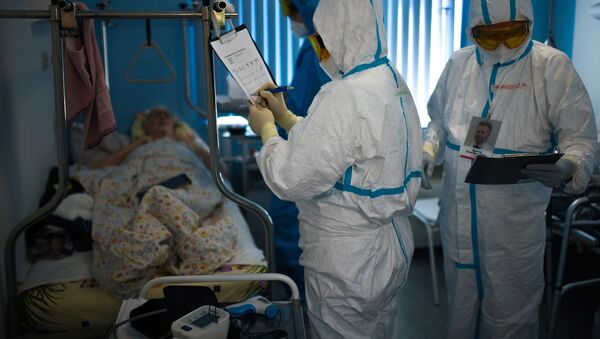 Врачи у постели пациента во время обхода в госпитале для лечения зараженных коронавирусной инфекцией  - Sputnik Беларусь