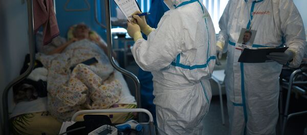 Врачи у постели пациента во время обхода в госпитале для лечения зараженных коронавирусной инфекцией  - Sputnik Беларусь
