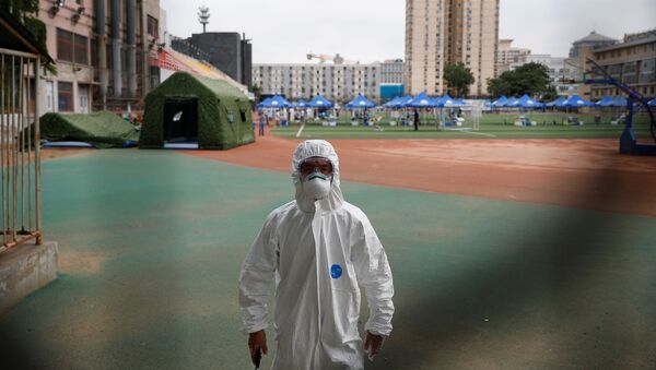 Сотрудник службы безопасности в защитном костюме на полигоне в спортивном центре Гуанань в Пекине - Sputnik Беларусь