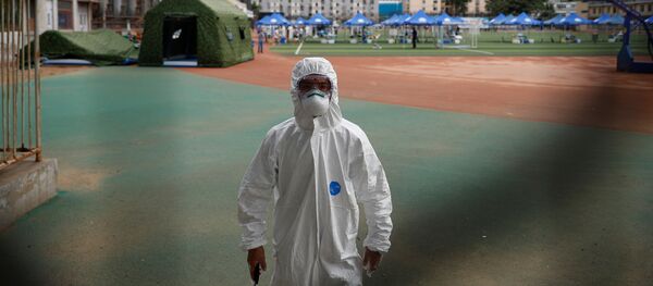 Сотрудник службы безопасности в защитном костюме на полигоне в спортивном центре Гуанань в Пекине - Sputnik Беларусь