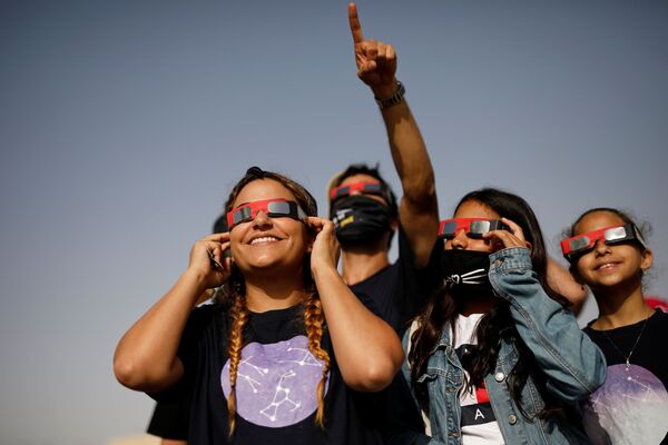 Молодежь в специальных очках смотрит за прохождением Луны по солнечному диску в Йерухаме, на юге Израиля - Sputnik Беларусь