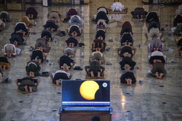 Индонезийцы возносят молитвы во время кольцевого солнечного затмения в мечети Аль-Акбар в Сурабая 21 июня 2020 года - Sputnik Беларусь