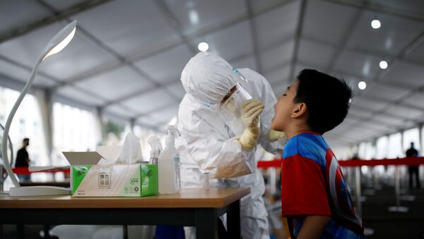Медицинский работник проводит тестирование на коронавирус школьнику в Пекине - Sputnik Беларусь