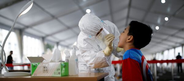 Медицинский работник проводит тестирование на коронавирус школьнику в Пекине - Sputnik Беларусь