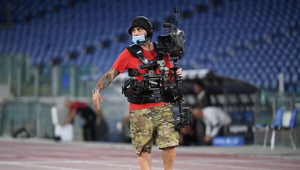 Оператор в защитной маске на стадионе Олимпико в Риме - Sputnik Беларусь