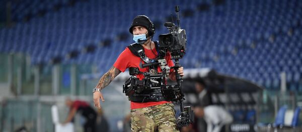 Оператор в защитной маске на стадионе Олимпико в Риме - Sputnik Беларусь