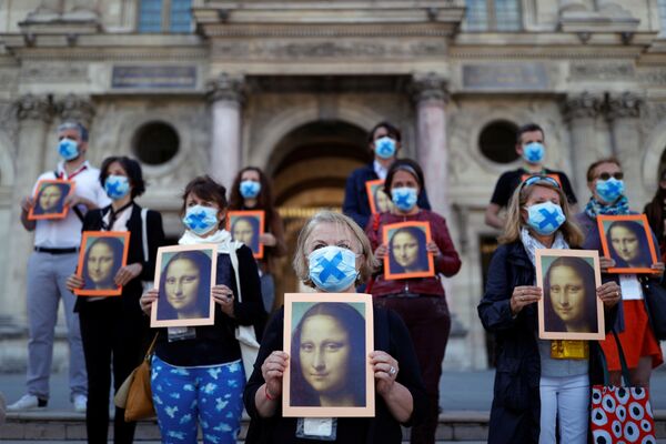 Парижские гиды держат плакаты с изображением картины Мона Лиза Леонардо да Винчи во время акции во дворе Лувра - Sputnik Беларусь